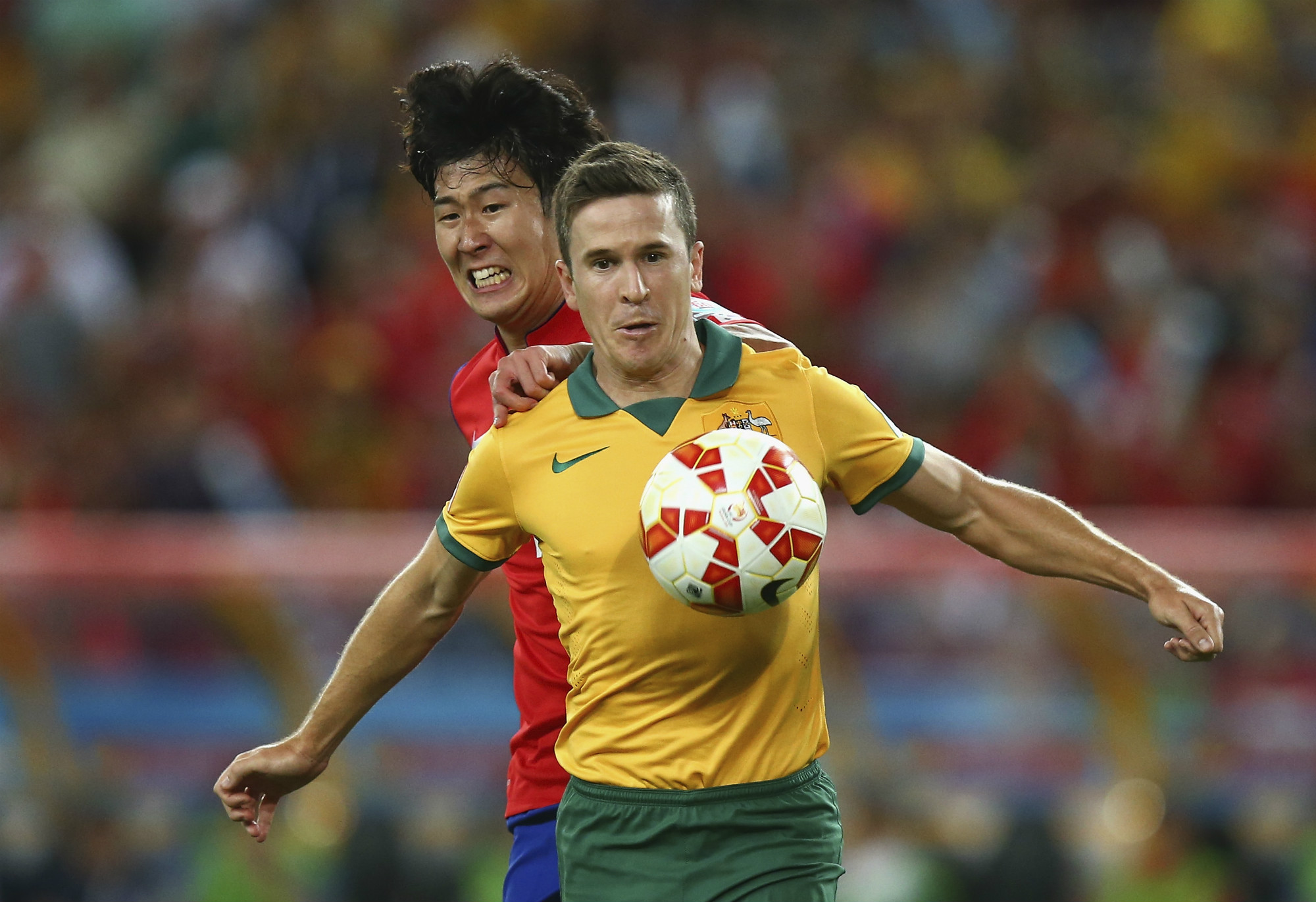 Matt McKay, playing for the Caltex Socceroos, is pressured by Son Heung-min