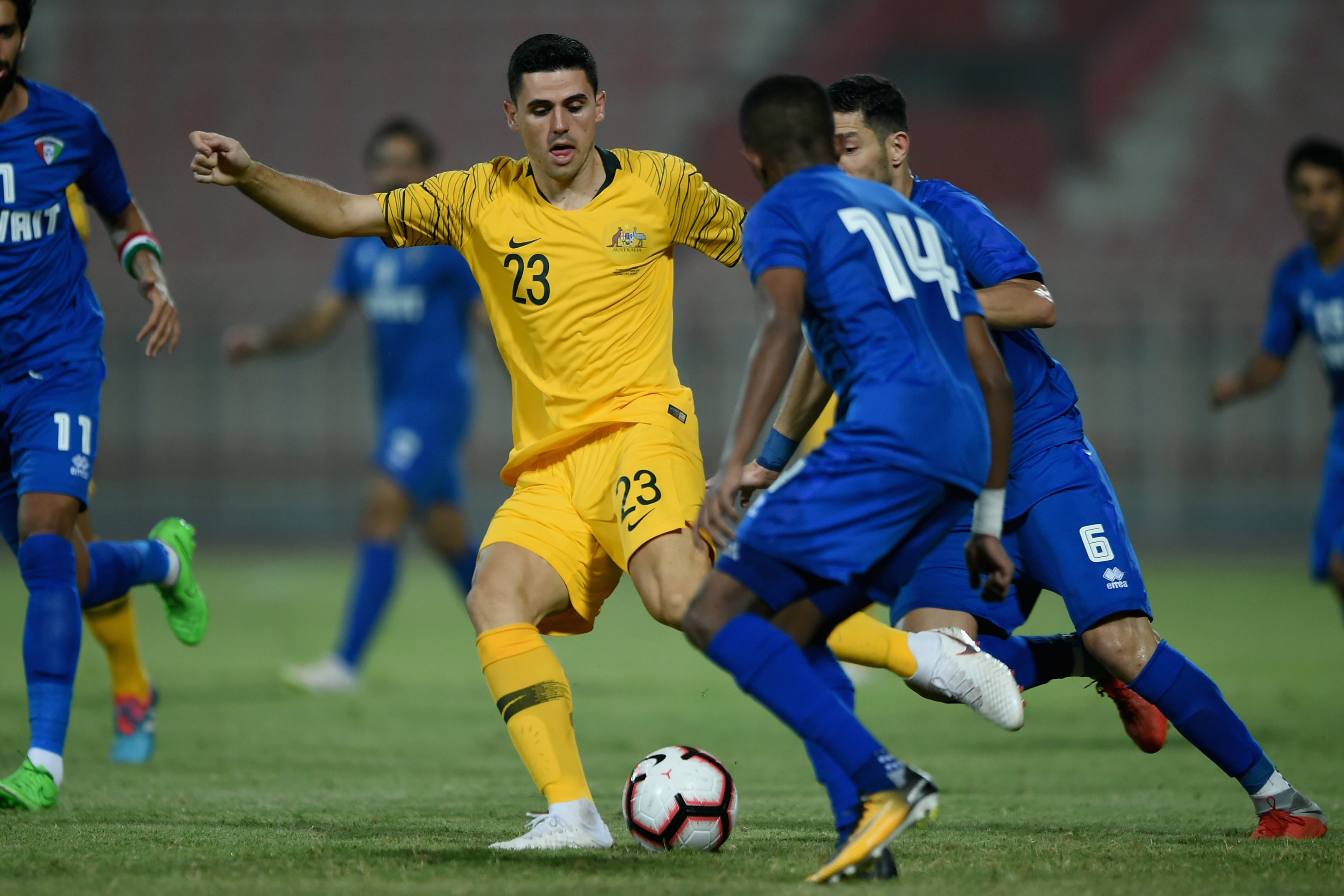 Tom Rogic tries to wriggle free of a couple of Kuwait defenders.