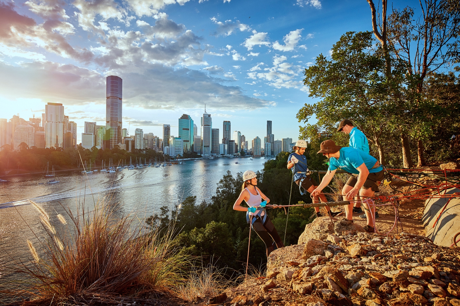 One female and one male cliff climbers getting ready with two staff Kangaroo Point