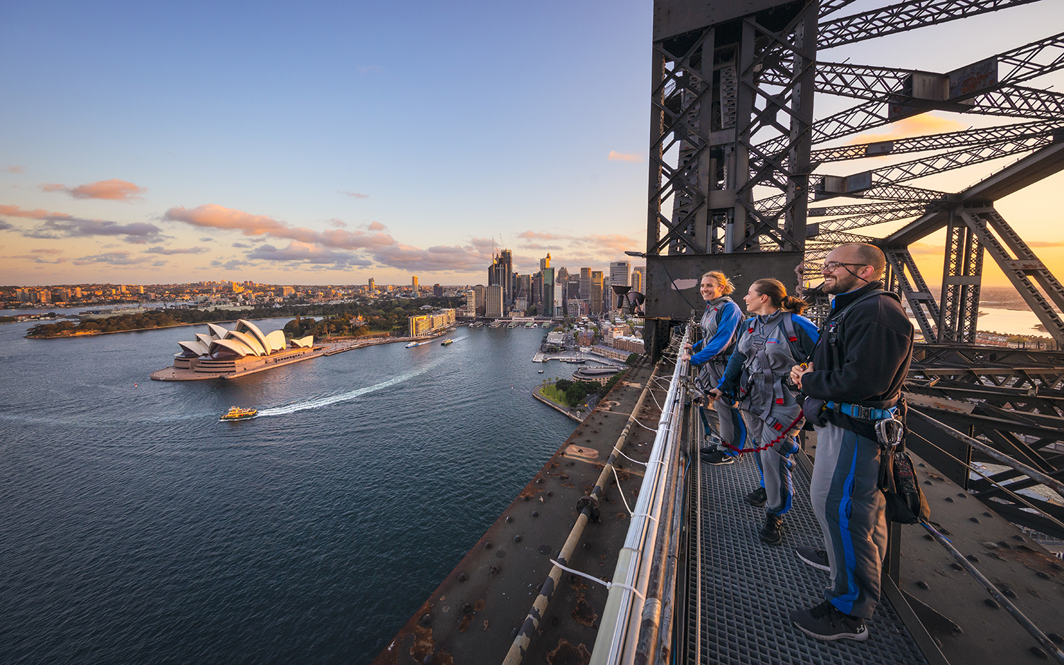 Friends enjoying a twilight BridgeClimb Sydney experience overlooking Sydney Harbour.