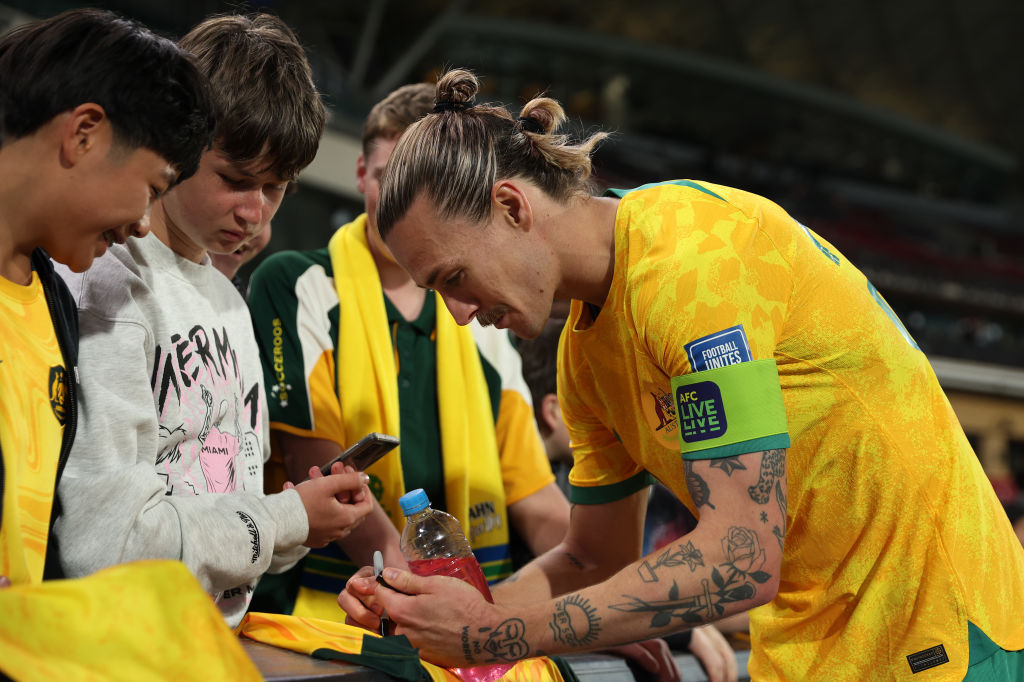 ADELAIDE, AUSTRALIA - OCTOBER 10: Jackson Irvine of the Socceroos signs a jersey after the third round FIFA World Cup 2026 Qualifier match between Australia Socceroos and China PR at Adelaide Oval on October 10, 2024 in Adelaide, Australia. (Photo by Maya Thompson/Getty Images)