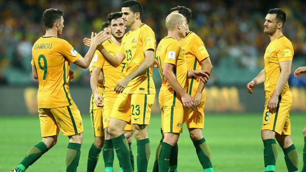 Tom Rogic celebrates with teammates after scoring against Tajikistan.