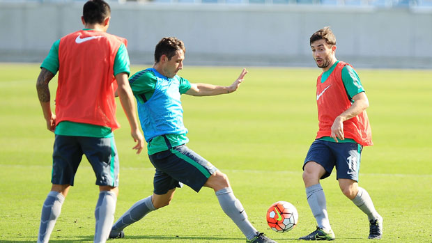 Mark Milligan challenges Tommy Oar in training.