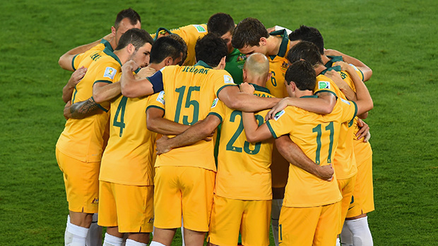 The Socceroos go into a huddle before kick-off against Chile.