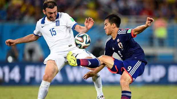 Vasilis Torosidis fights for the ball against Japan.