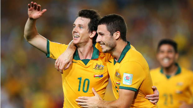 Robbie Kruse celebrates scoring against Oman with teammate Mathew Leckie.