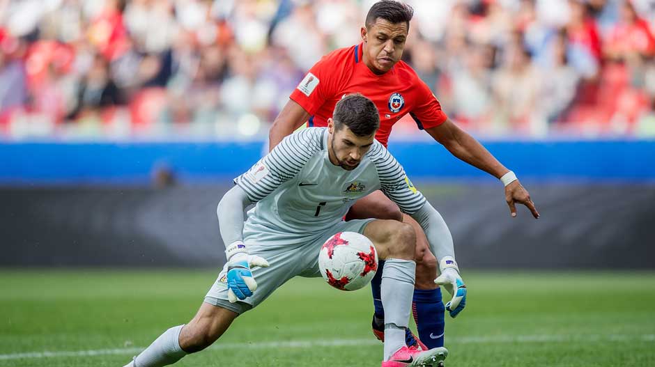 Goalkeeper Mat Ryan scoops on a loose ball just before Alexis Sanchez looks to pounce.