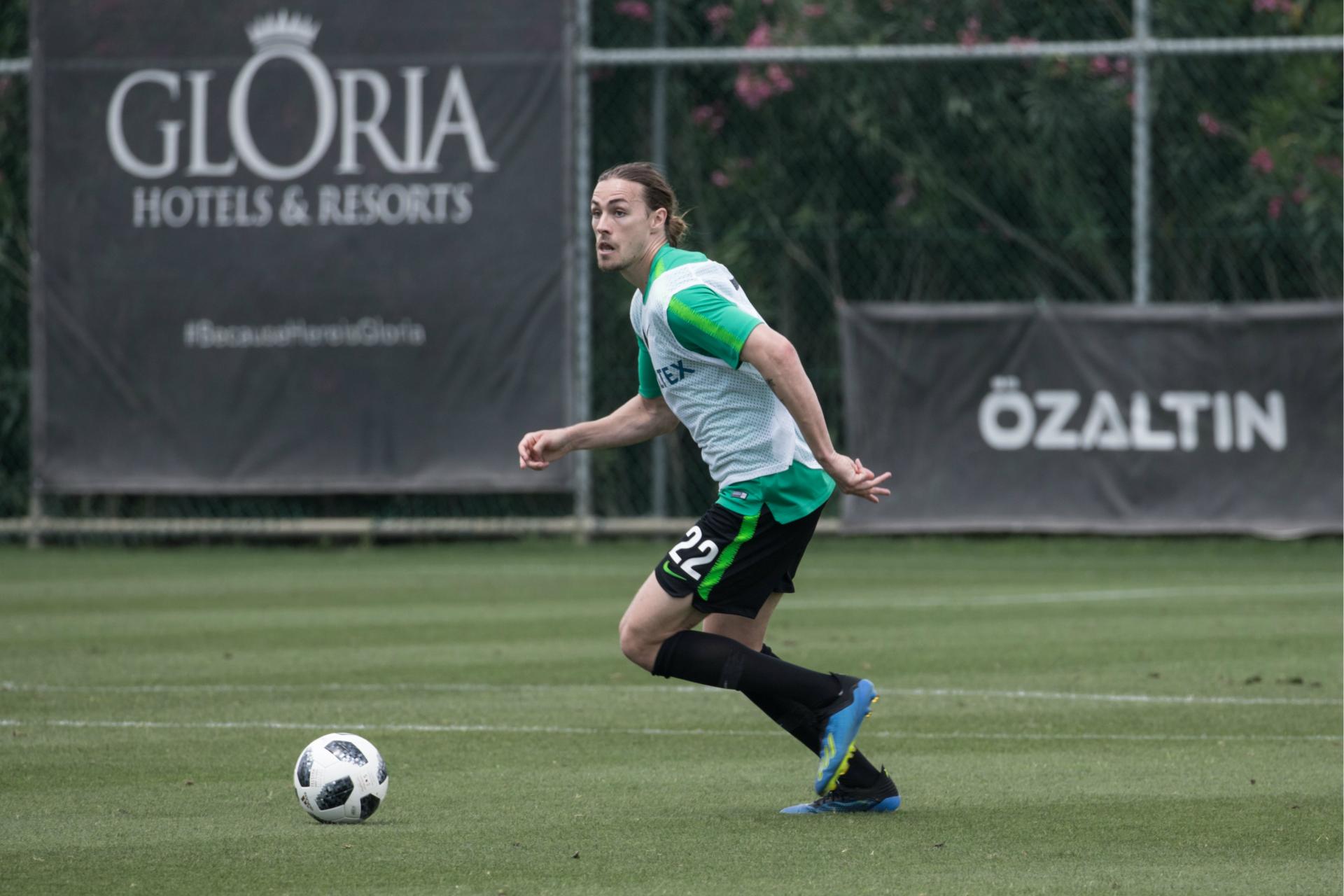 Midfielder Jackson Irvine striding forward with the ball.