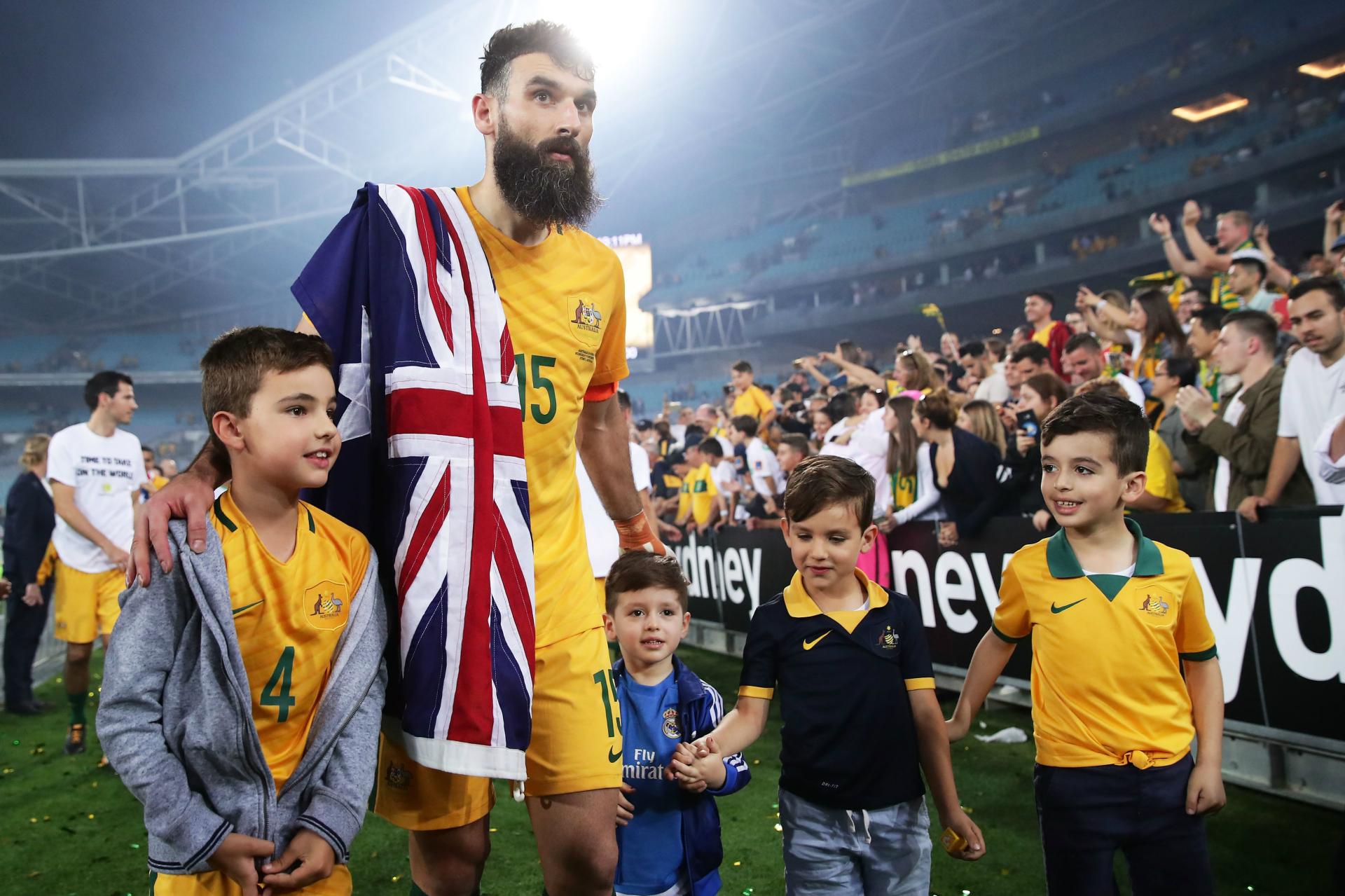 Jedinak celebrating with family after the 3-0 win at ANZ Stadium last November.