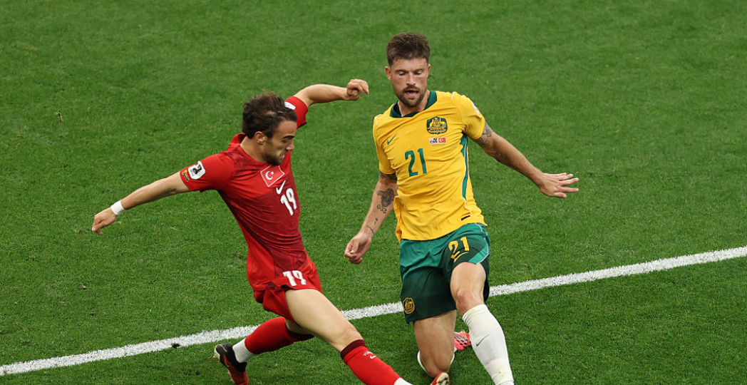 VANCOUVER, BRITISH COLUMBIA - JUNE 13: Yunus Akgun #19 of Turkiye and Cameron Burgess #21 of Australia compete for the ball during the FIFA World Cup 2026 Group D match between Australia and Türkiye at BC Place Vancouver on June 13, 2026 in Vancouver, British Columbia. (Photo by Richard Heathcote/Getty Images)