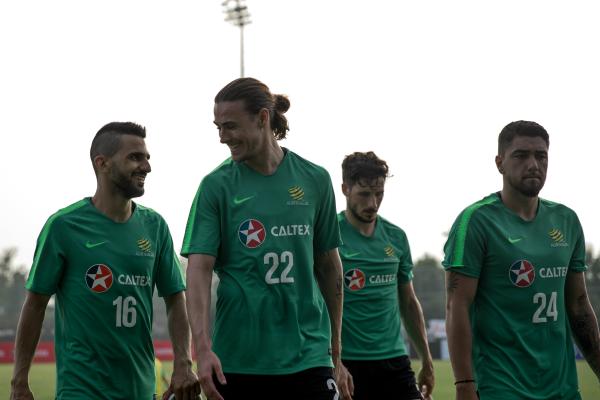 Jackson Irvine and Aziz Behich share a joke.