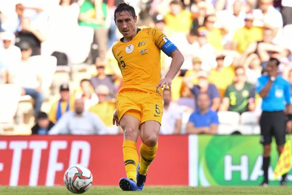 Socceroos skipper Mark Milligan gets a pass away.