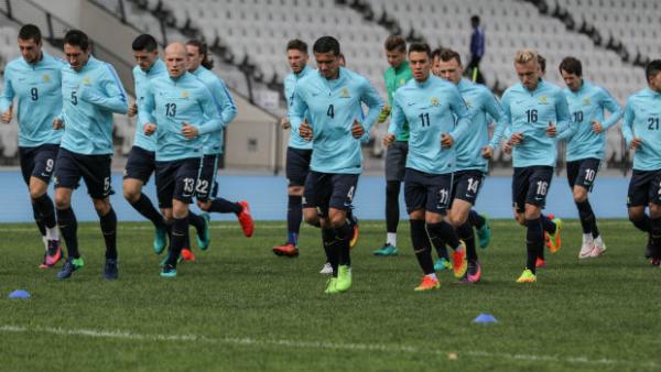 The Caltex Socceroos go on a warm-up jog during their open training session in Melbourne on Sunday.
