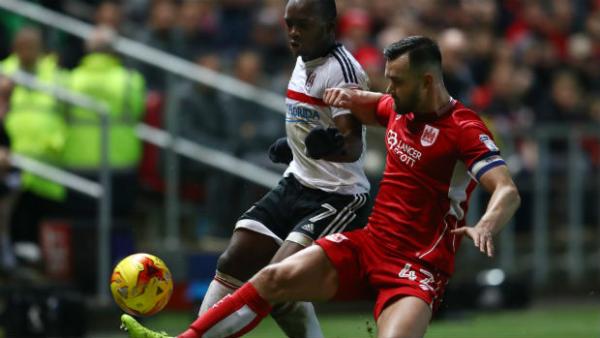 Defender Bailey Wright makes a tackle on Fulham's Neeskens Kebano in the Championship.