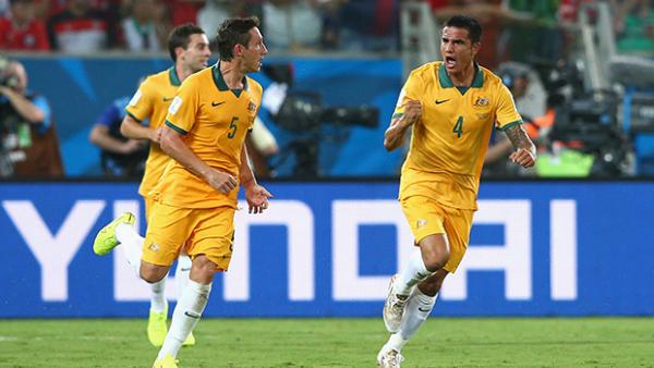 Millgan celebrates with Tim Cahill after Australia scored against Chile.