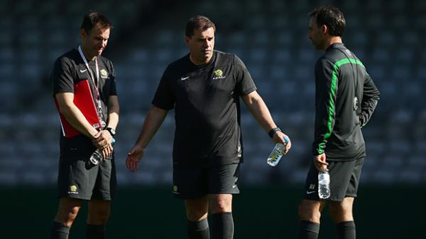 Socceroos head coach Ange Postecoglou talks tactics with assistants Ante Milicic and Aurelio Vidmar.