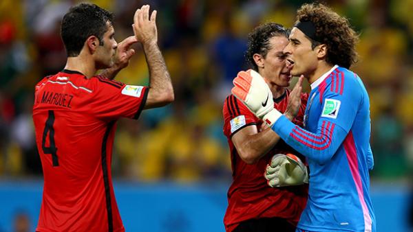 Ochoa reacts after making a save with Rafael Marquez and Andres Guardado.