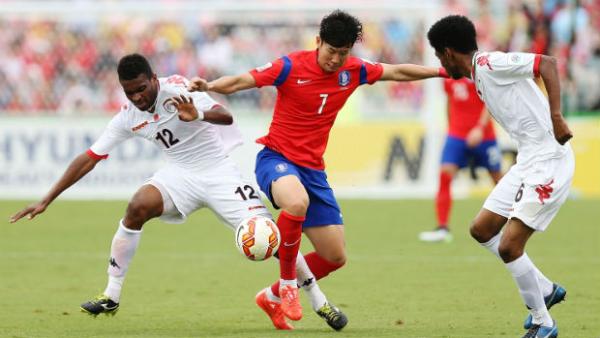 Korea Republic's Son Heung Min tries to evade the Omani defence.