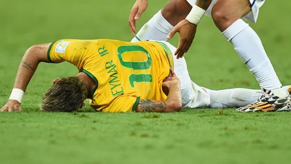 Brazilian star Neymar clutches his back after a heavy challenge from Colombia's Juan Zuniga.