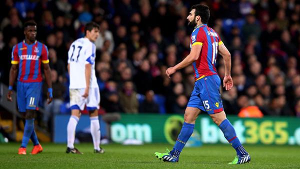 Mile Jedinak leaves the pitch after receiving a red card.