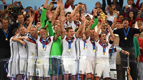 Germany captain Philipp Lahm lifts the World Cup trophy and celebrates with teammates.