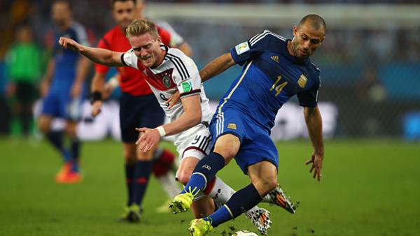 Andre Schuerrle of Germany and Javier Mascherano of Argentina compete for the ball.