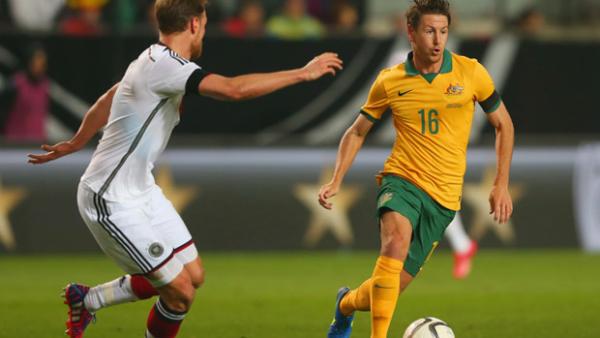Nathan Burns takes on German defender Benedikt Höwedes in Kaiserslautern.