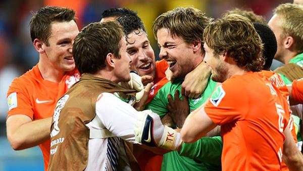 Goalkeeper Tim Krul is embraced by teammates after the Dutch are victorious in a penalty shootout.