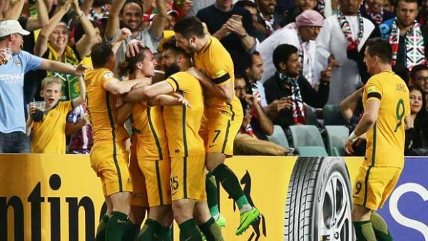 The Caltex Socceroos players swamp Jackson Irvine after his early goal in the win over UAE.