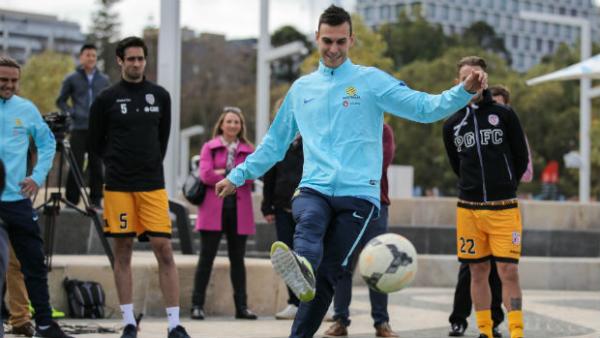 Defender Trent Sainsbury kicks a ball with some young Socceroos fans in Perth.