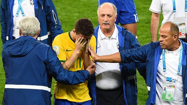 Brazil coach Luiz Felipe Scolari tries to console a dejected Oscar after Brazil's World Cup exit.