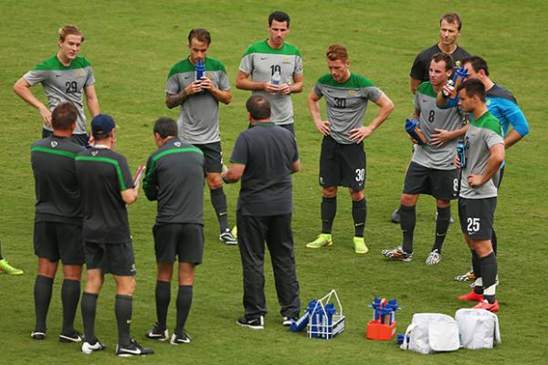 The Socceroos receive some advice from coach Ange Postecoglou at half-time against Parana Clube.
