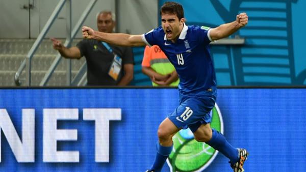 Sokratis Papastathopoulos celebrates a Greece goal at the 2014 FIFA World Cup.
