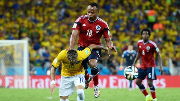 Colombia's Juan Camilo Zuniga bundles into the back of Brazilian star Neymar.