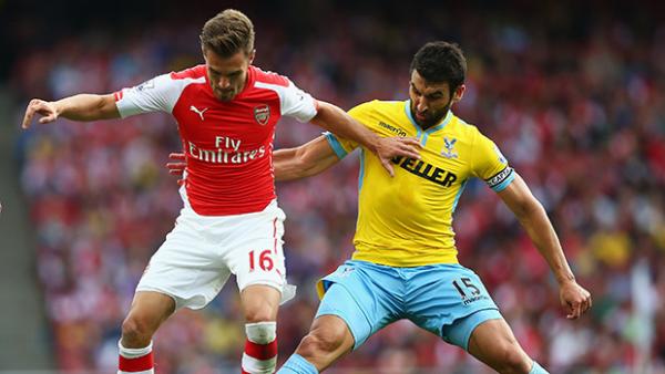 Crystal Palace captain Mile Jedinak performs a tackle on Arsenal's Aaron Ramsey.