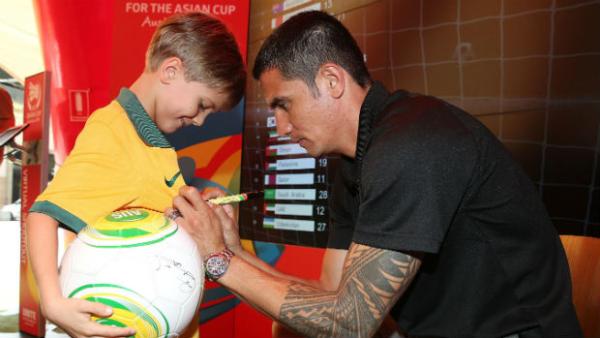 Tim Cahill signs a young Socceroos fan's jersey.