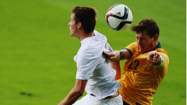Young Socceroos skipper Riley Woodcock wins a header against Andrew Blake.