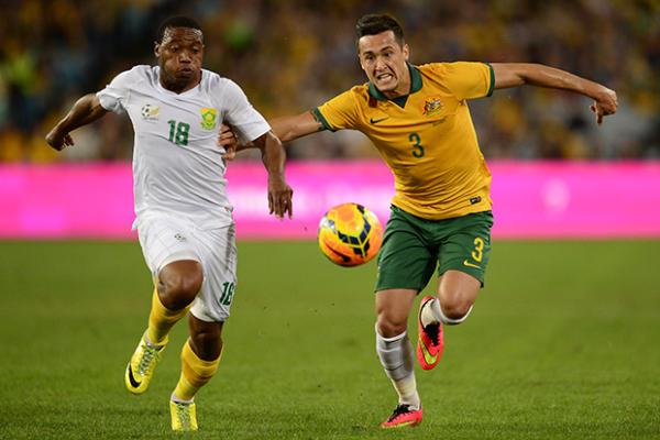 Socceroo Jason Davidson battles for possession with South Africa's Thuso Phala in Australia's farewell match.