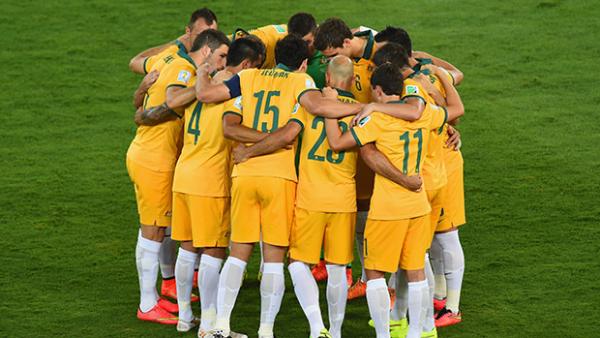 The Socceroos form a team huddle before kick-off against Chile.