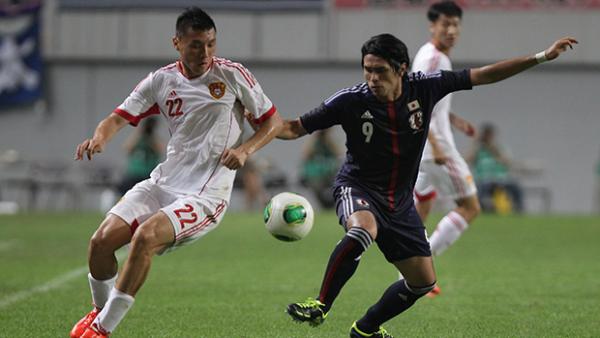 Masato Kudo of Japan and Yu Dabao of China compete for the ball during the EAFF East Asian Cup.