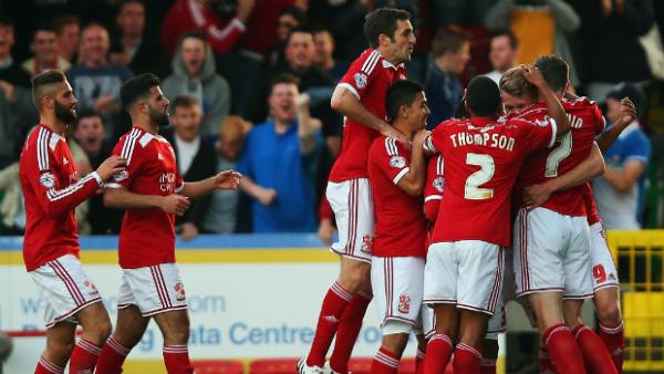 Swindon Town players celebrate one of their goals against Sheffield United in their League One play-off.